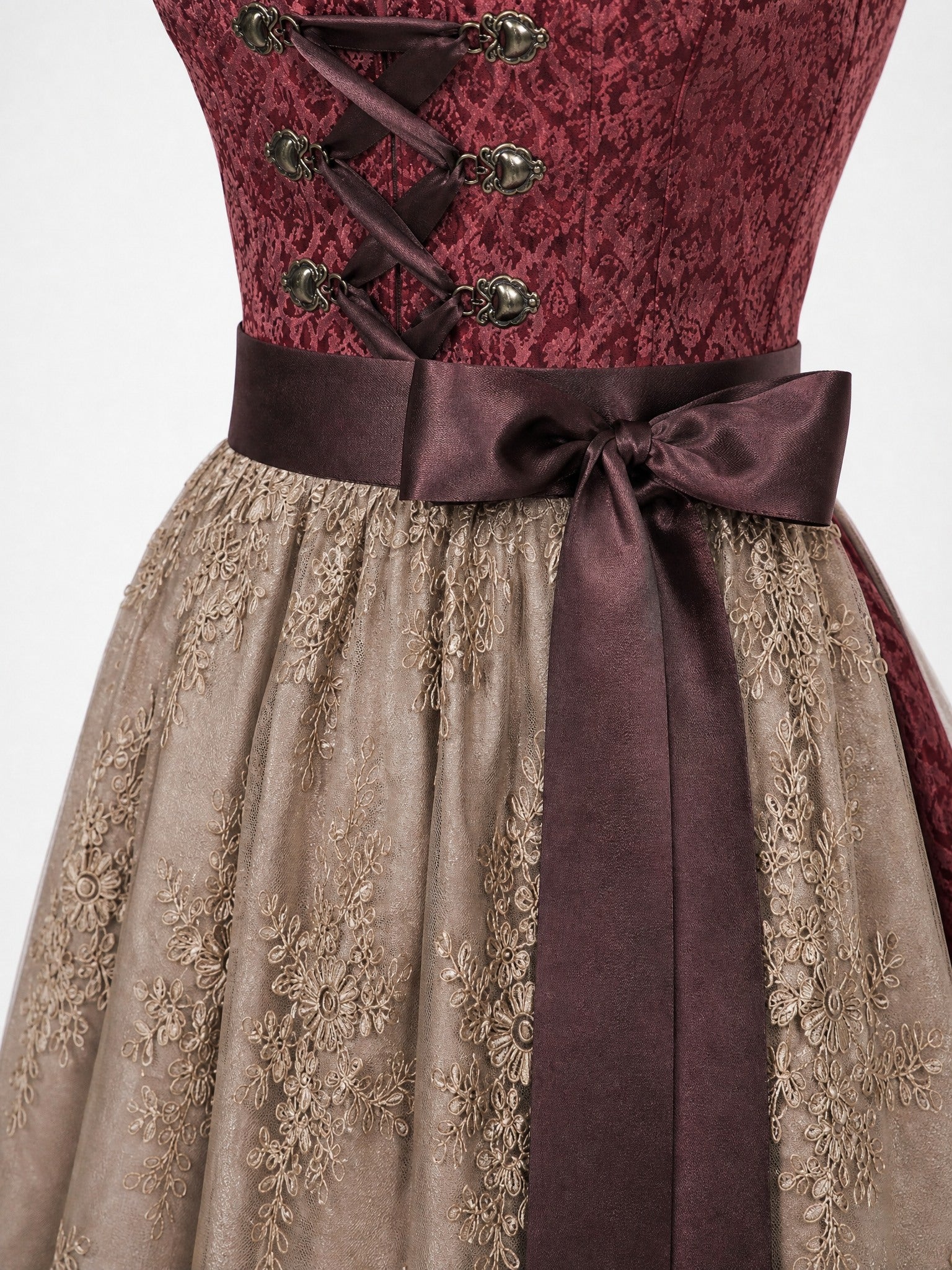 Dirndl Cecilia in Weinrot mit Taupe Schürze - Detailansicht Taille und Schleife