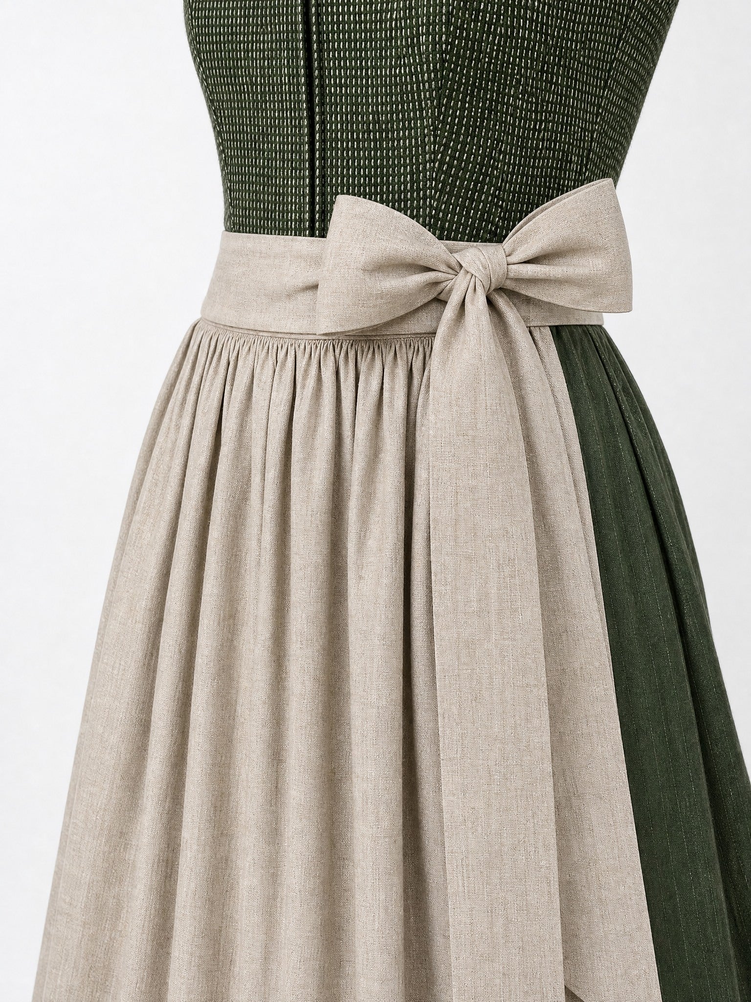 Dirndl Ilvy in Waldgrün mit Haferbeige Schürze - Detailansicht Taille und Schleife