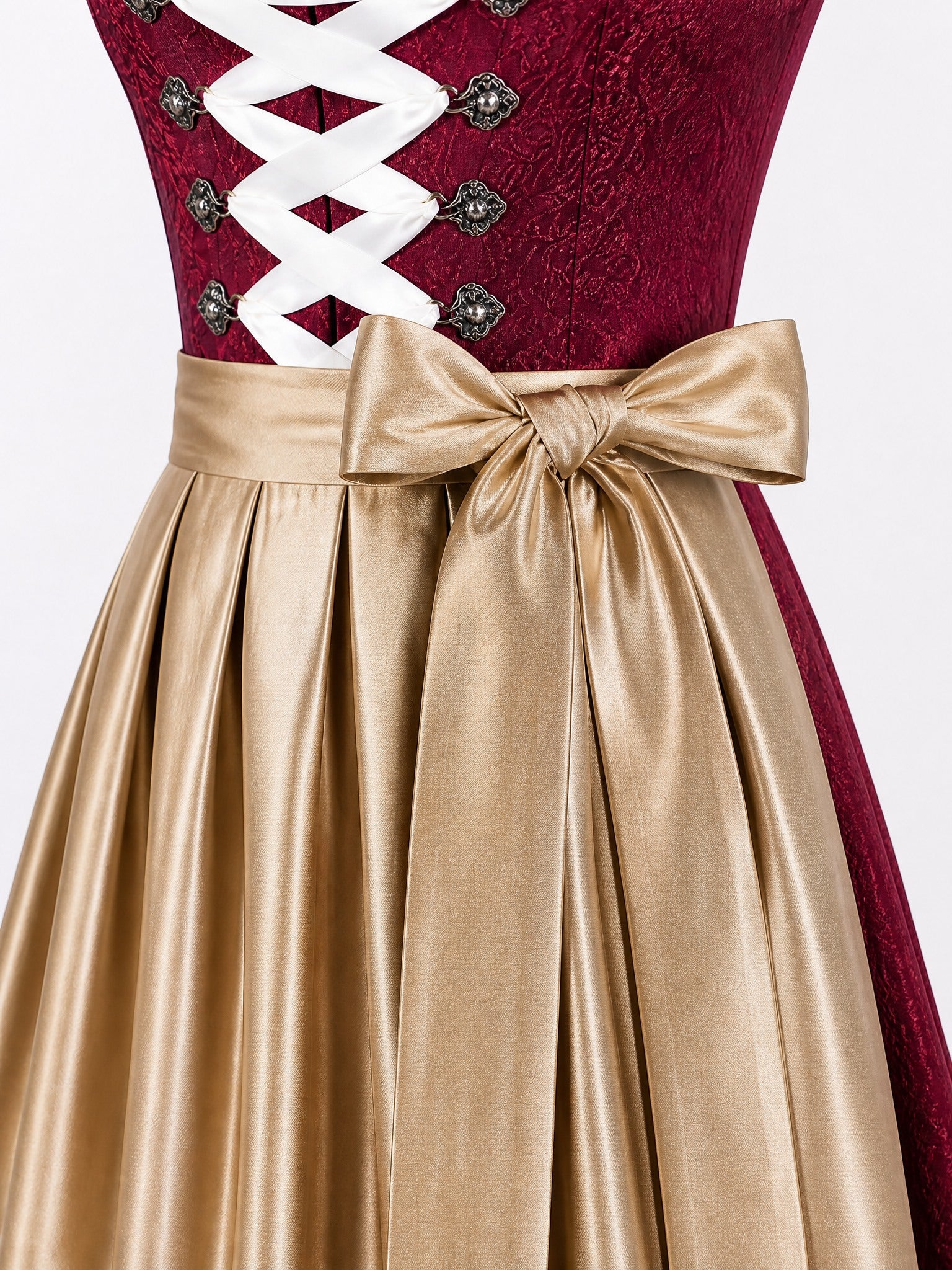 Dirndl Karla in Cranberryrot mit Antikgold Schürze - Detailansicht Taille und Schleife